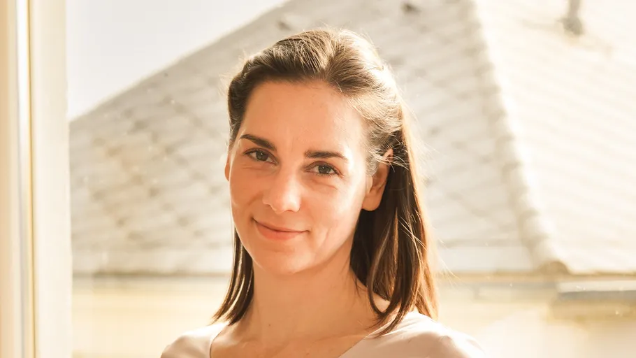 Smiling woman indoors near a window.