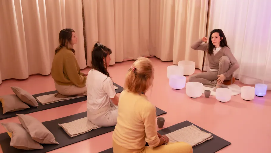 Vier Personen in Meditationssitzung mit Schalen.