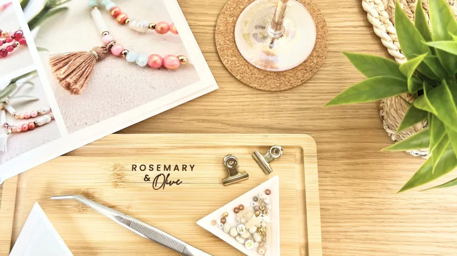 Jewelry-making tools and beads on wooden table.