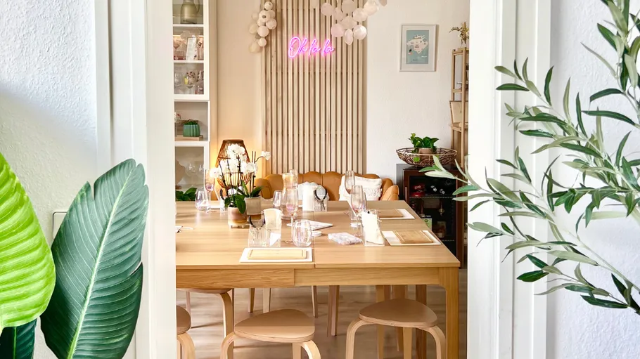 Esszimmer mit Holztisch, Pflanzen und Dekoration.