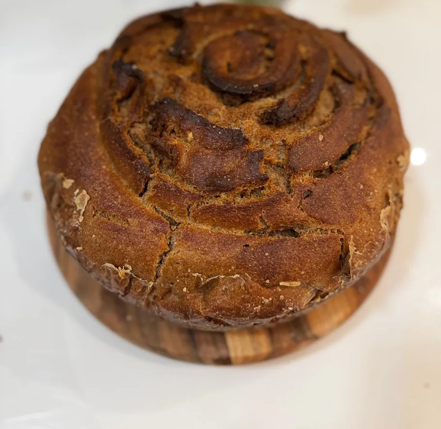 Round, crusty bread on a wooden board.