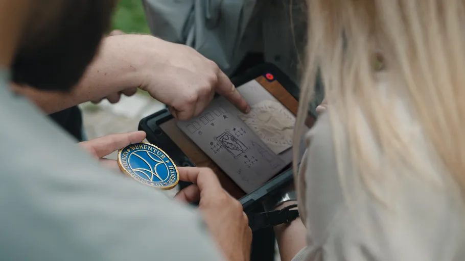 Personen betrachten Tablet mit technischen Zeichnungen.