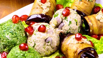 Gefüllte Auberginenröllchen mit garniertem Salat.