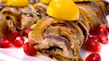 Stuffed eggplant rolls garnished with pomegranate seeds.