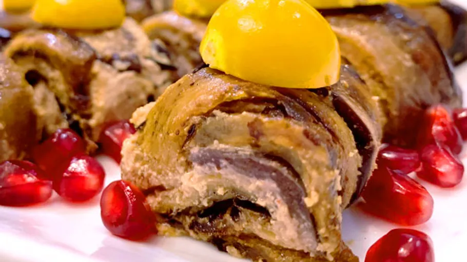 Stuffed eggplant rolls garnished with pomegranate seeds.