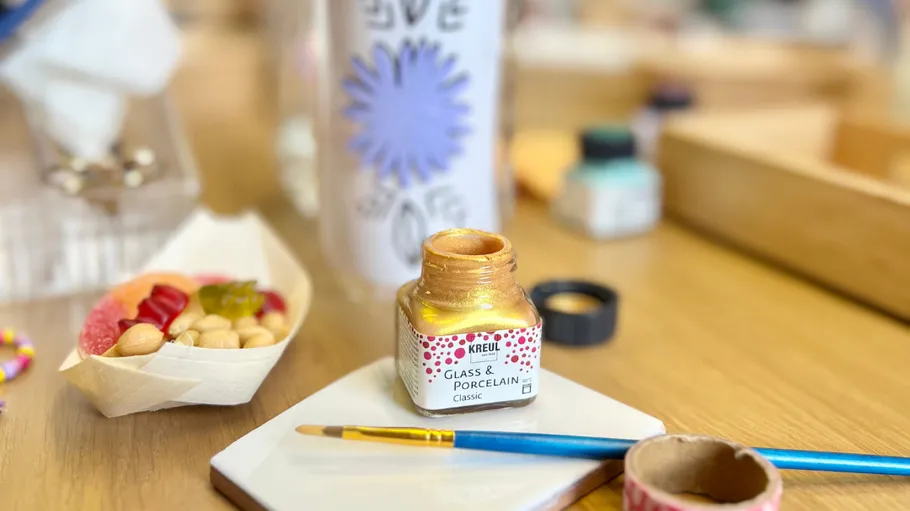 Gold paint and brush on table.