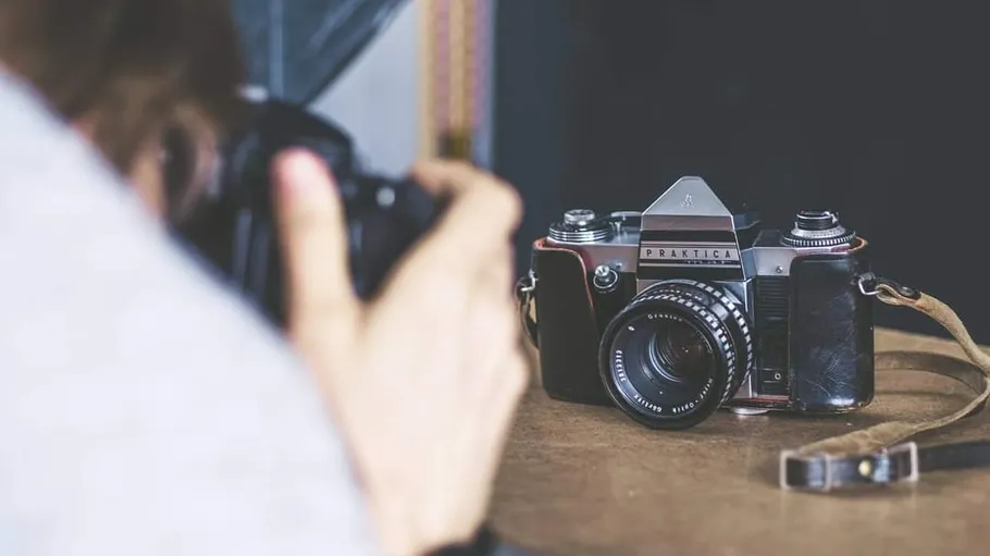 Vintage camera on table photographed by person.