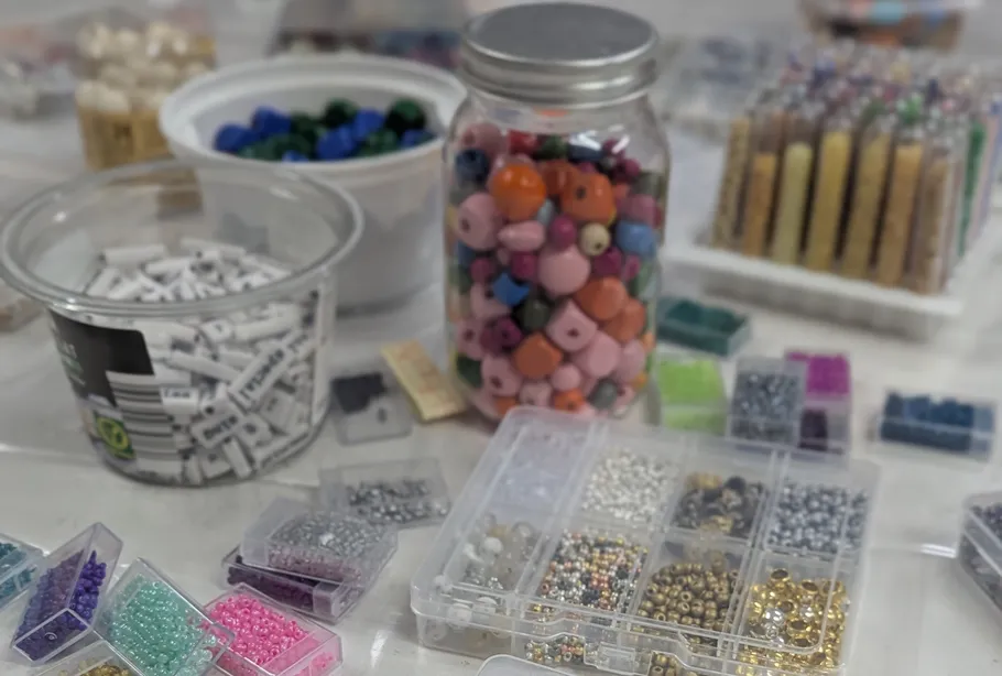 Beads in containers on a crafting table.