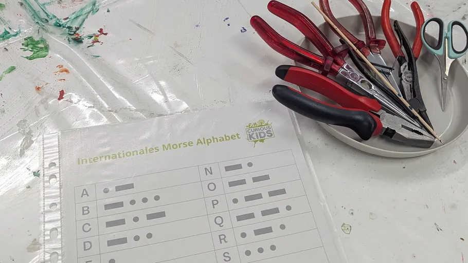 Tools on plate next to Morse code sheet.