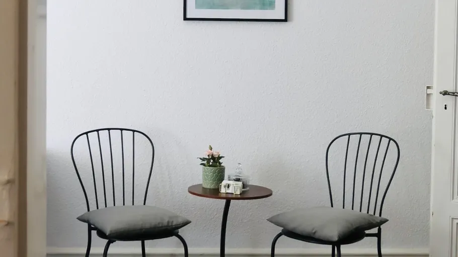 Two chairs flanking a small table in a room.