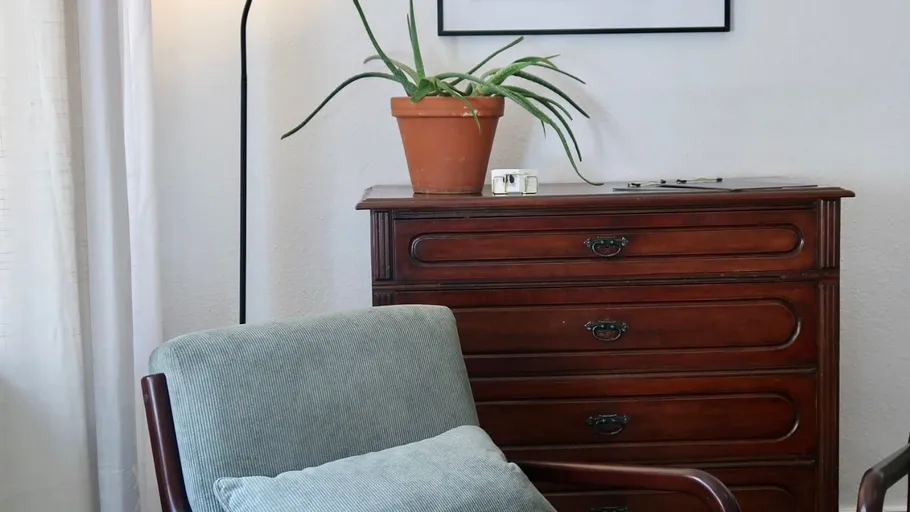 Chair and dresser in a cozy room.