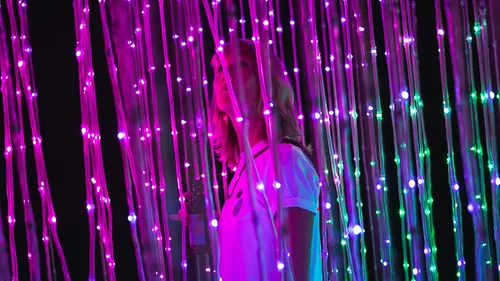 Person geht durch bunte Lichterinstallation.