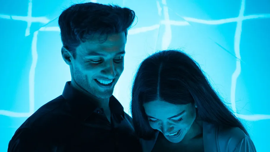 Lächelndes Paar im blauen Licht beleuchtet.