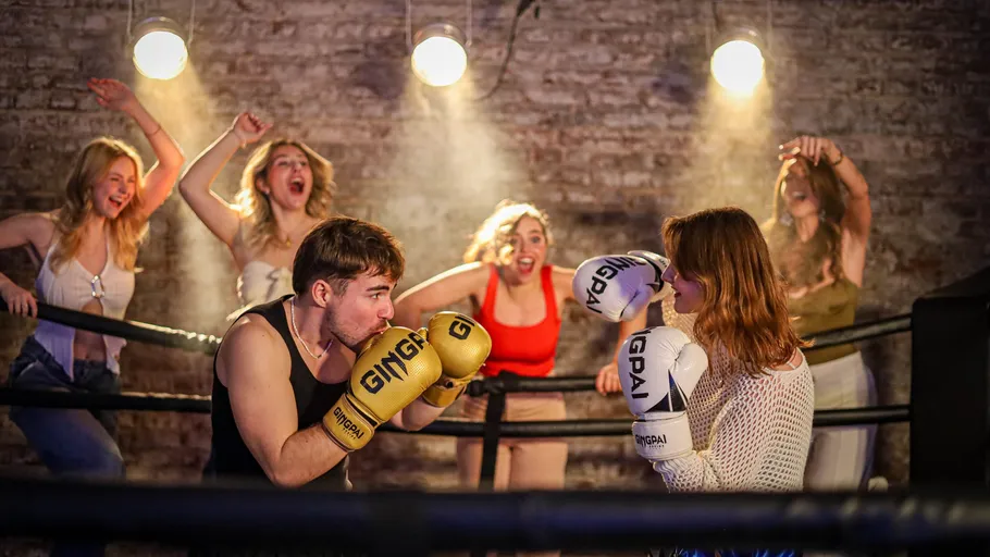 Two people boxing, surrounded by cheering friends.