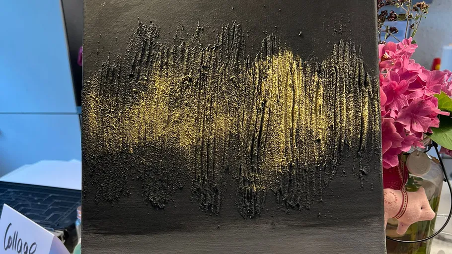 Black and gold textured painting on display.