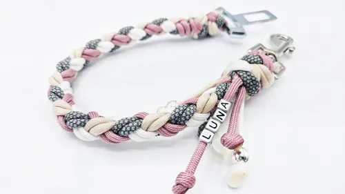 Braided pink, gray, and white bracelet on display.