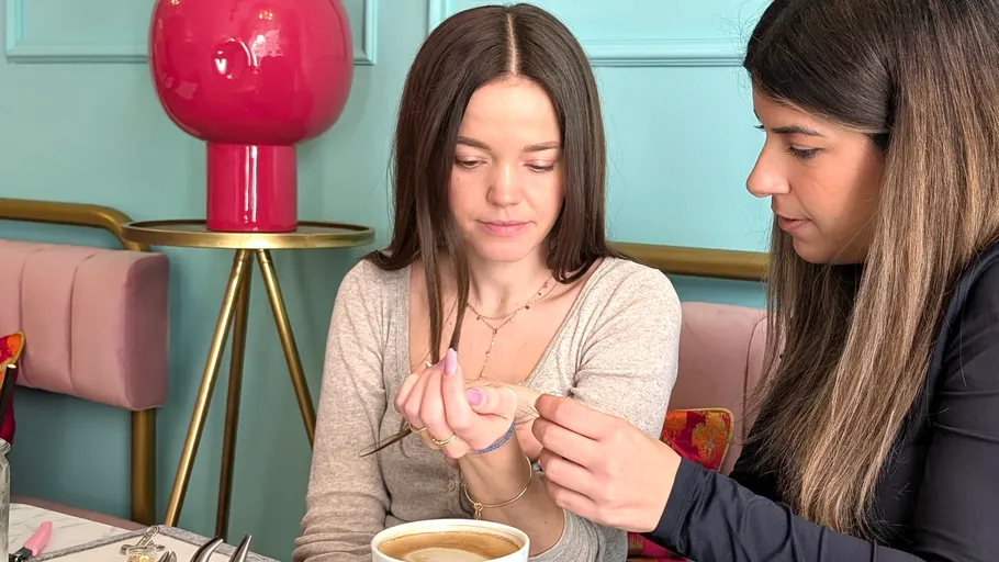 Zwei Frauen machen Nagelkunst im Café.