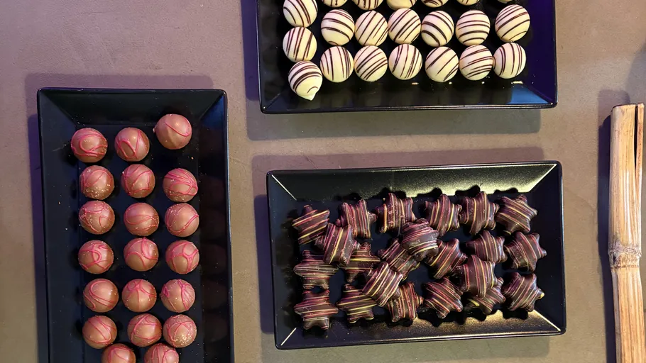 Three trays of assorted chocolate truffles.