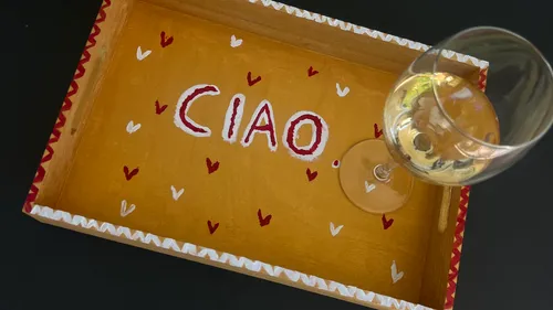 Tablett mit 'CIAO', Weinglas darauf.