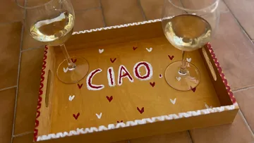 Two wine glasses on a decorated tray.