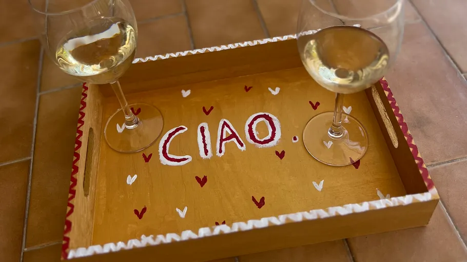 Two wine glasses on a decorated tray.