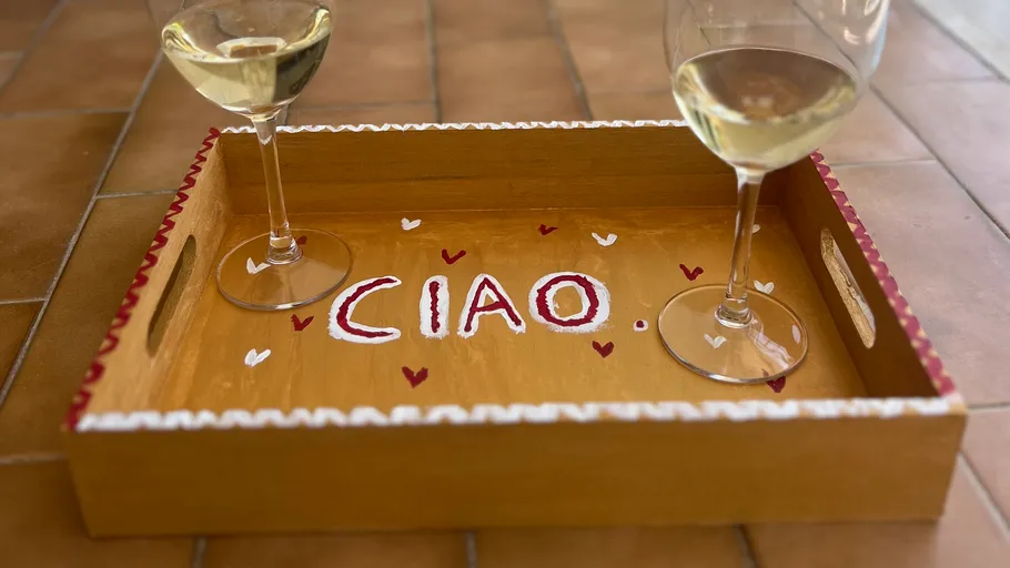 Two wine glasses on a decorated tray.