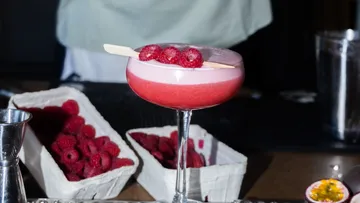 Raspberry cocktail with foam in elegant glass.