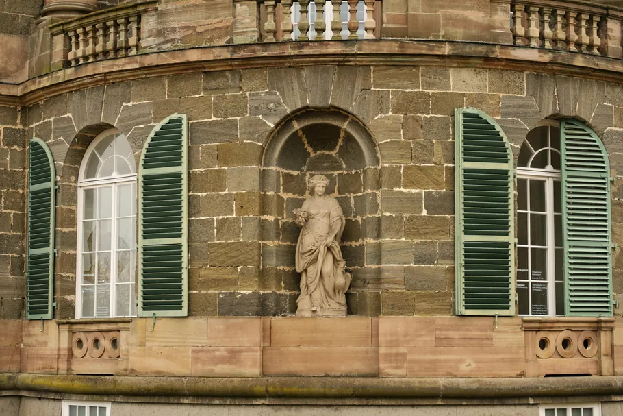 Statue in niche on historic building facade.