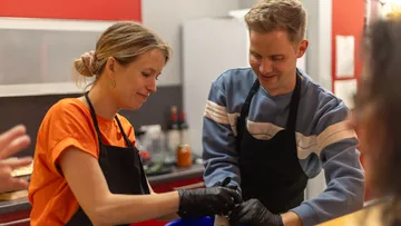Two people cooking together in a kitchen.