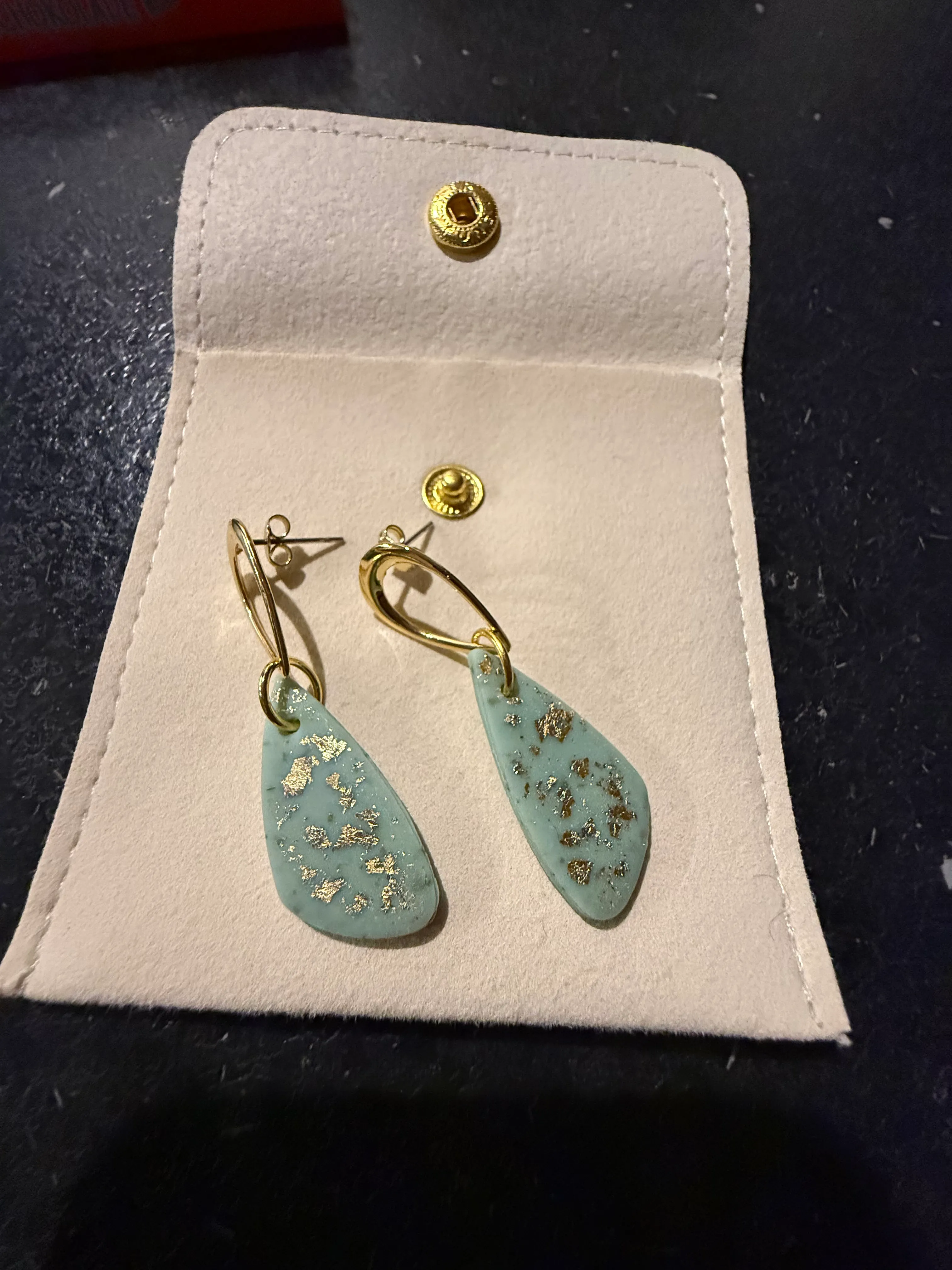 Ohrringe mit türkisen Steinen in einem Etui.