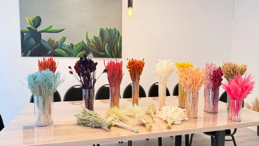 Bunte Trockenblumen in Vasen auf Tisch.