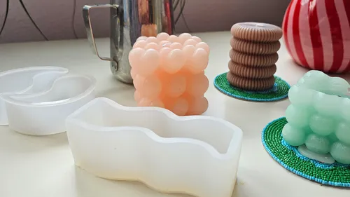 Bunte Kerzen und Formen auf einem Tisch.