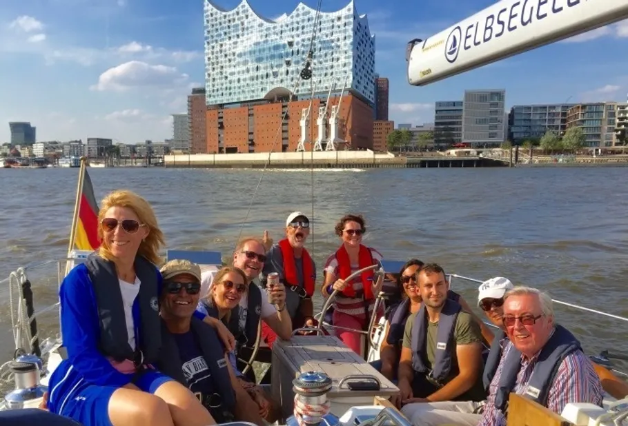 Gruppe auf Segelboot in Hamburg, Elbphilharmonie im Hintergrund.