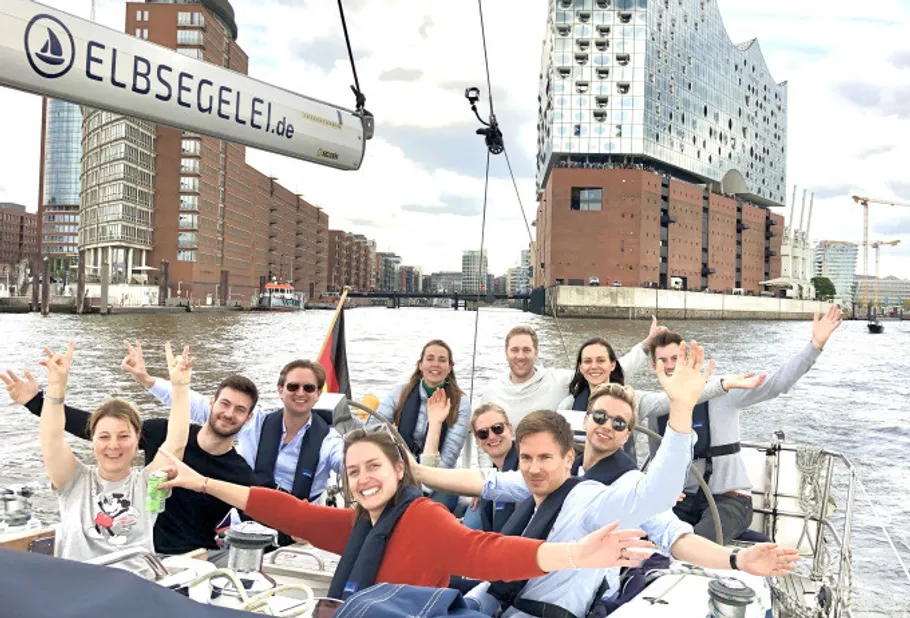 Group of people sailing near modern building.