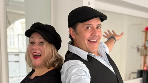 Zwei lachende Personen mit Hüten drinnen.