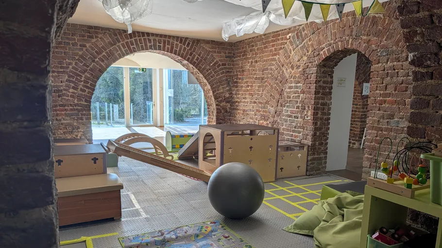 Children's playroom with toys and brick walls.