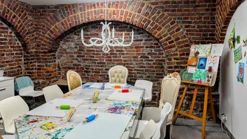 Kunststudio mit Ziegelwänden und Tischaufstellung.