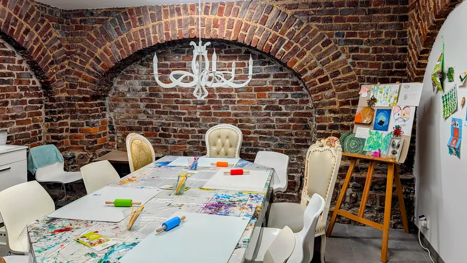 Kunststudio mit Ziegelwänden und Tischaufstellung.