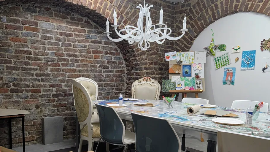 Workshop room with art supplies and chandelier.
