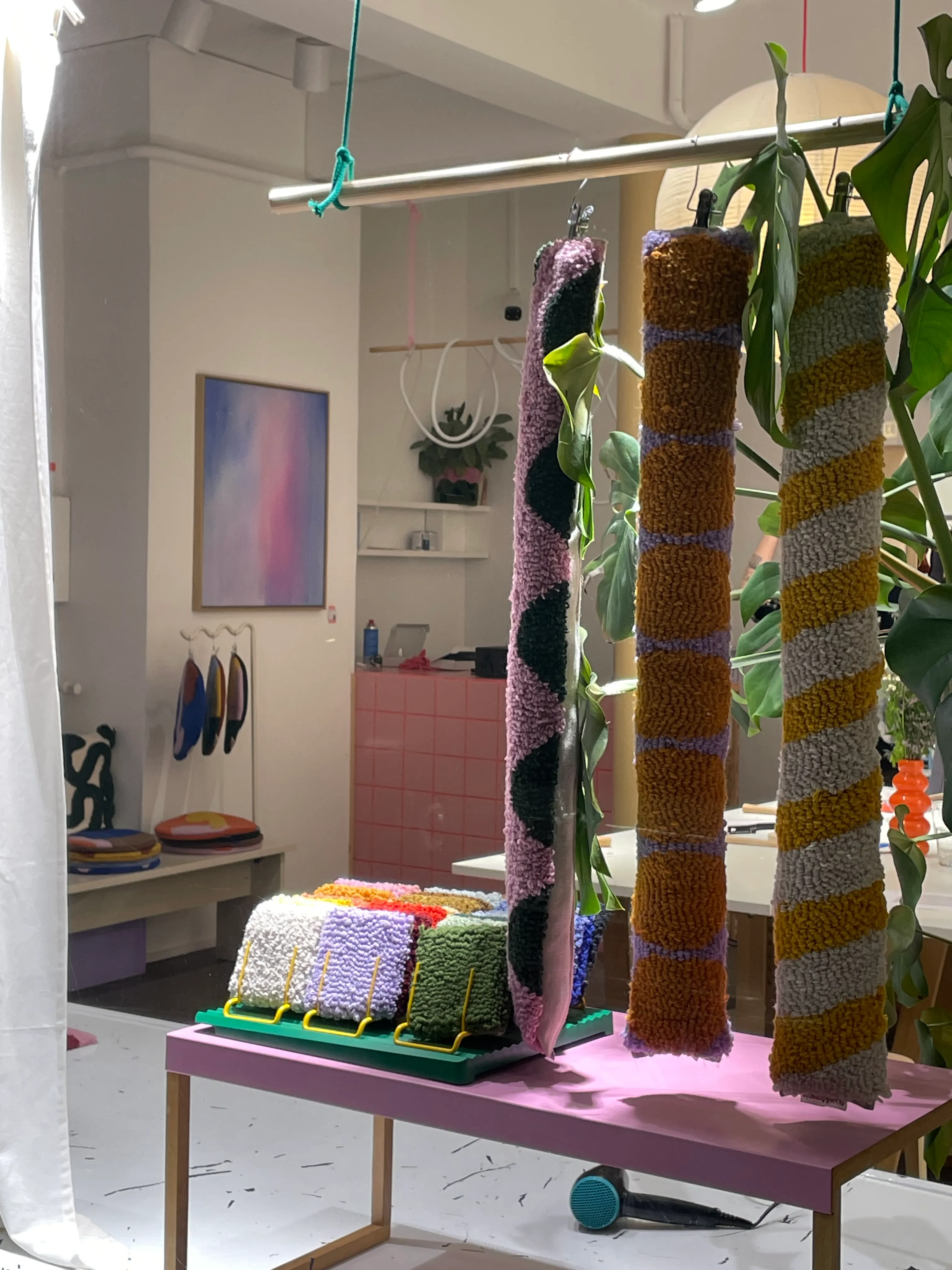 Bunte Garn-Dekorationen hängen im Studio.