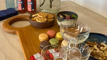 Snacks und Getränke auf Holzbrett.
