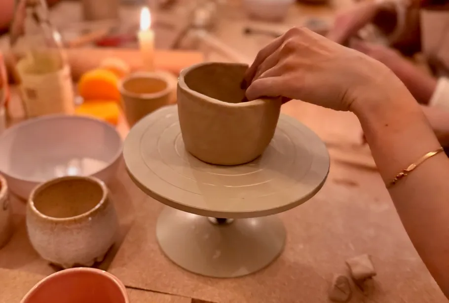 Hand shaping clay pot on pottery wheel.