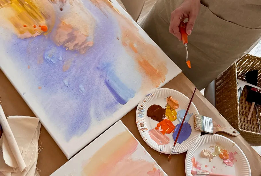 Artist painting with palette knife on canvas.