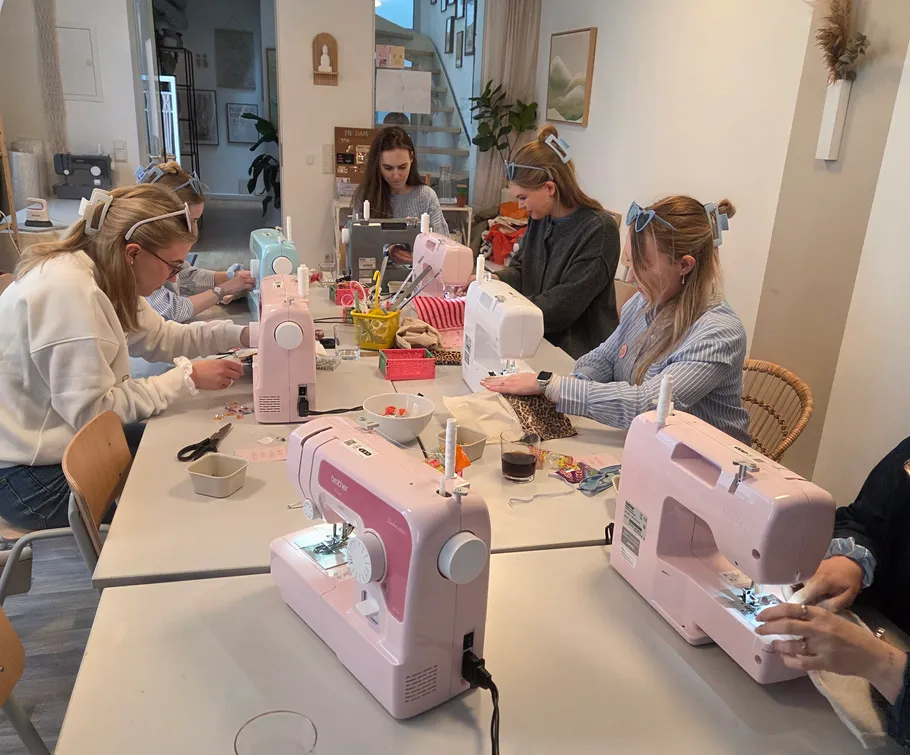 Frauen nähen mit Maschinen in einem Workshop.