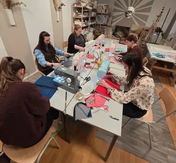 People sewing with machines in a workshop.