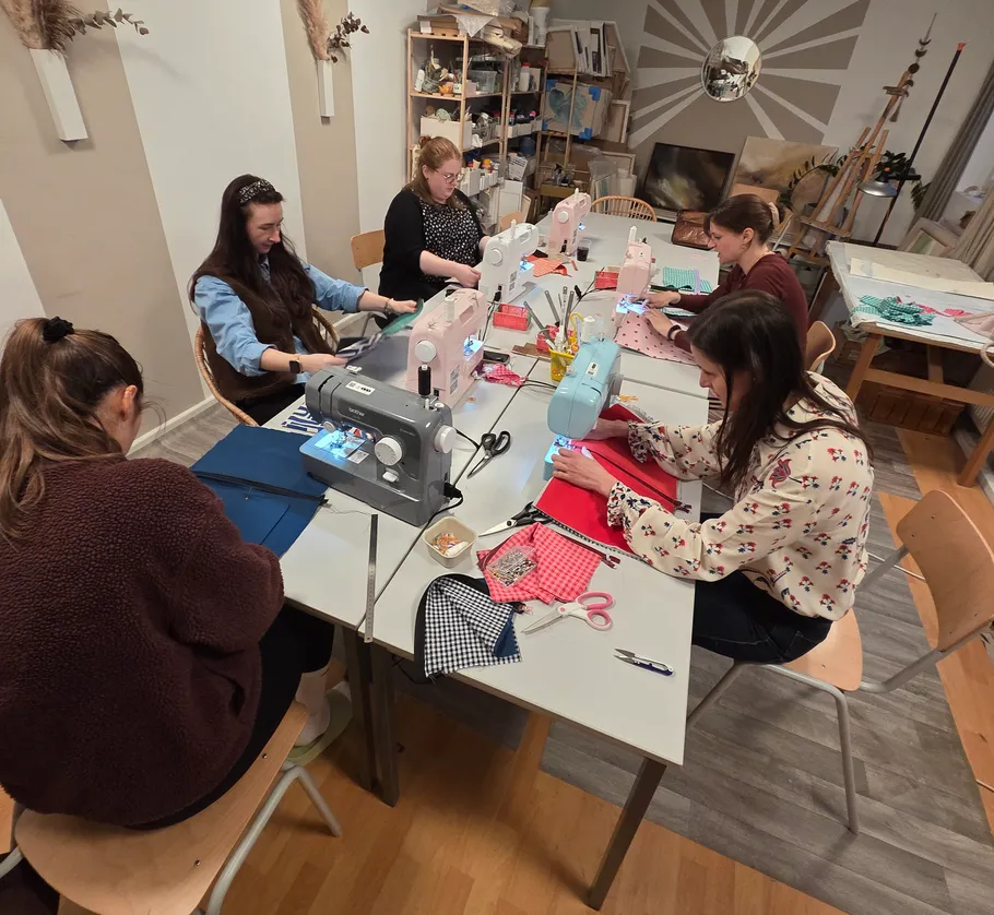 People sewing with machines in a workshop.