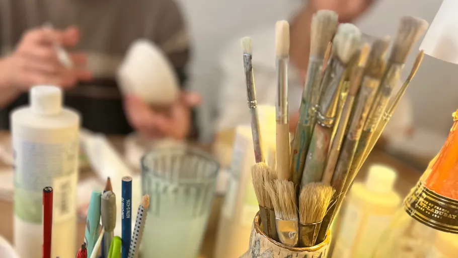 Pinsel und Kunstbedarf auf einem Tisch.