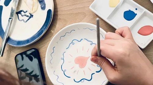 Hand painting ceramic plate with heart design.