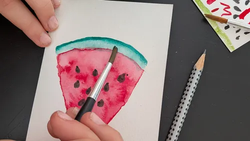 Hand painting watermelon slice on paper.