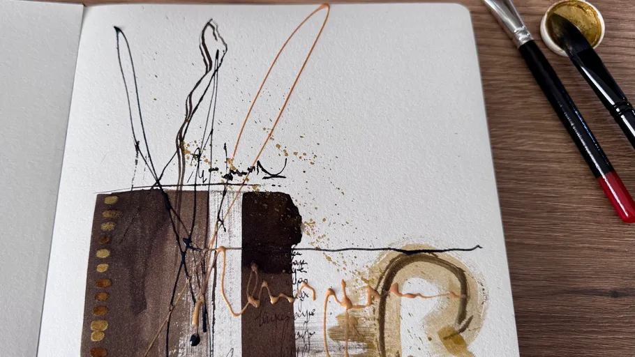 Abstract art with brushes on wooden table.